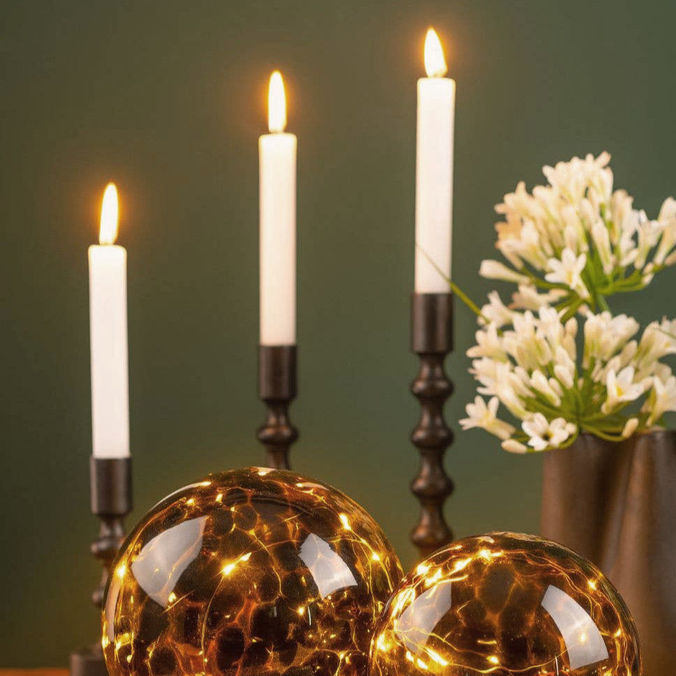 Tris portacandele di diverse altezze in metallo nero opaco con stelo lavorato a nodi per home decor e decorazioni autunnali.