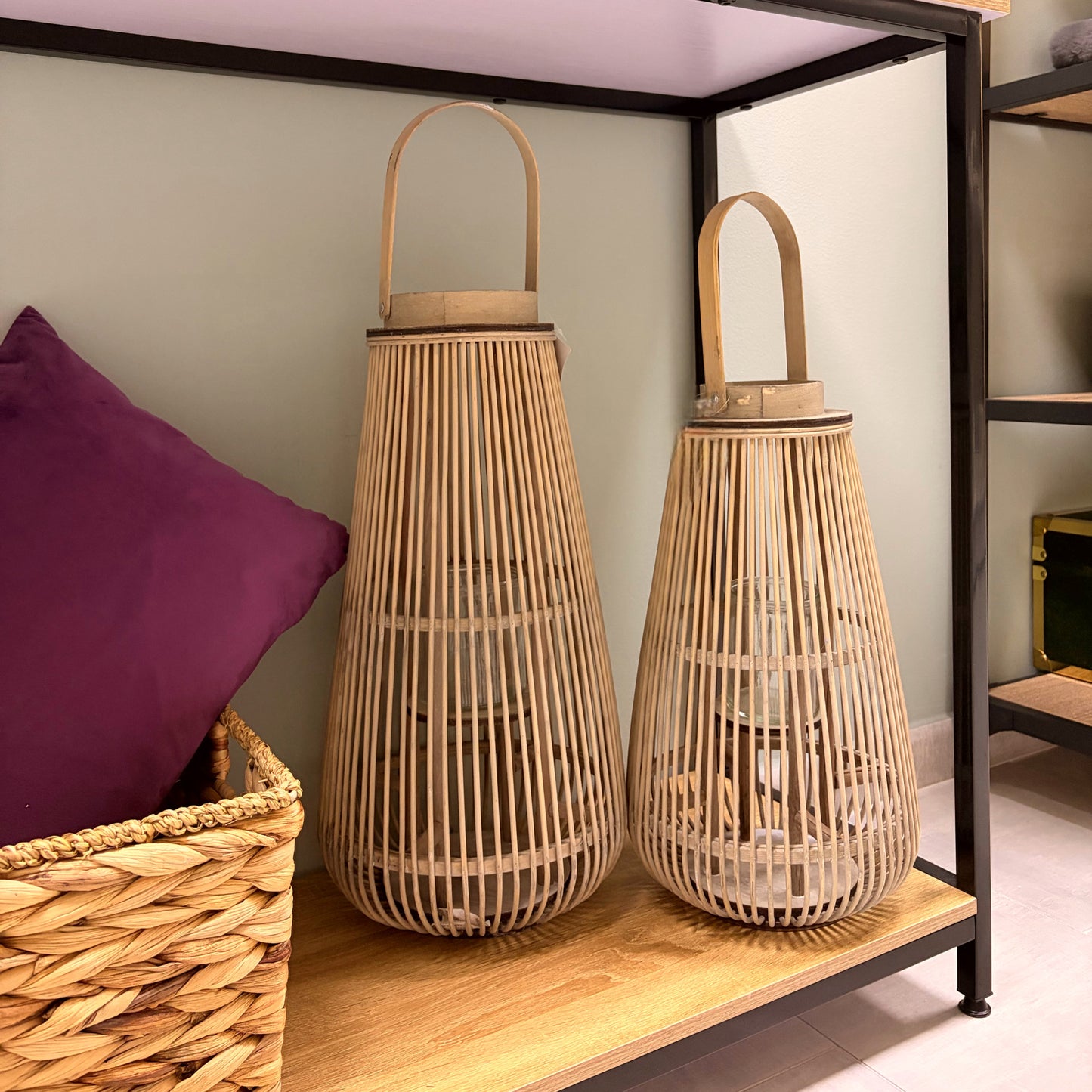 Set di due lanterne portacandele grandi in bambù naturale grezzo stile boho chic su una consolle in legno moderna