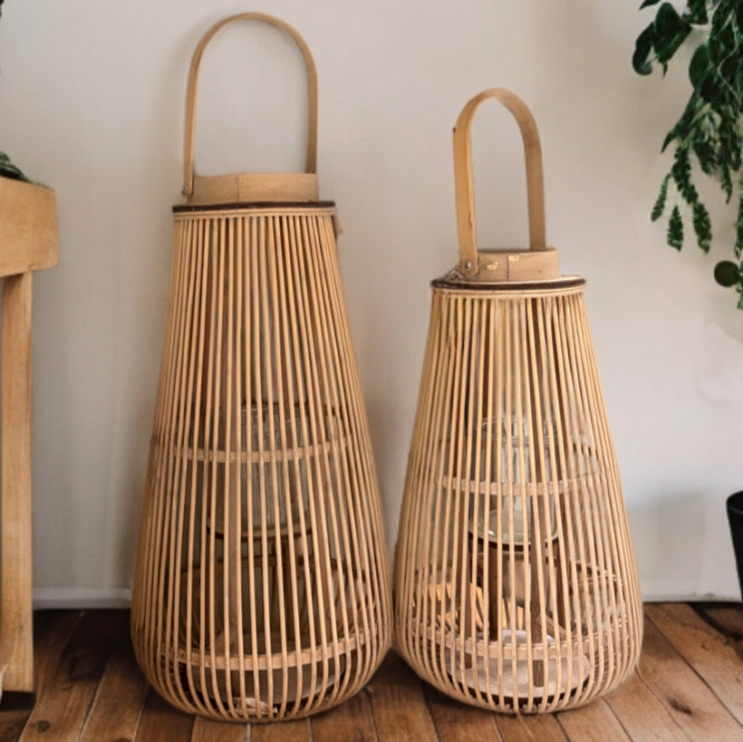 Set di due lanterne portacandele grandi in bambù naturale grezzo stile boho chic su pavimento in legno